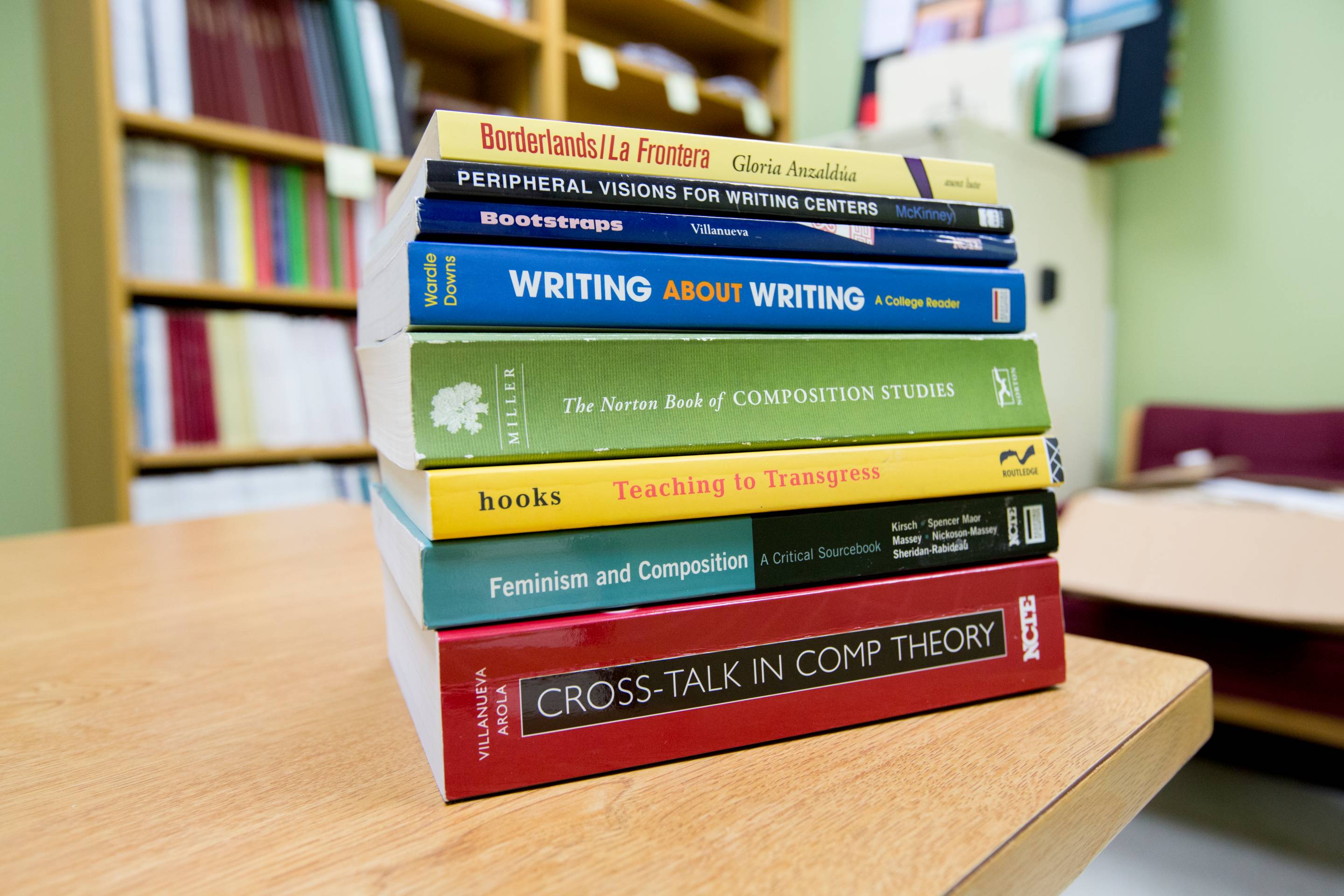 Stack of books on a table in a classroom.