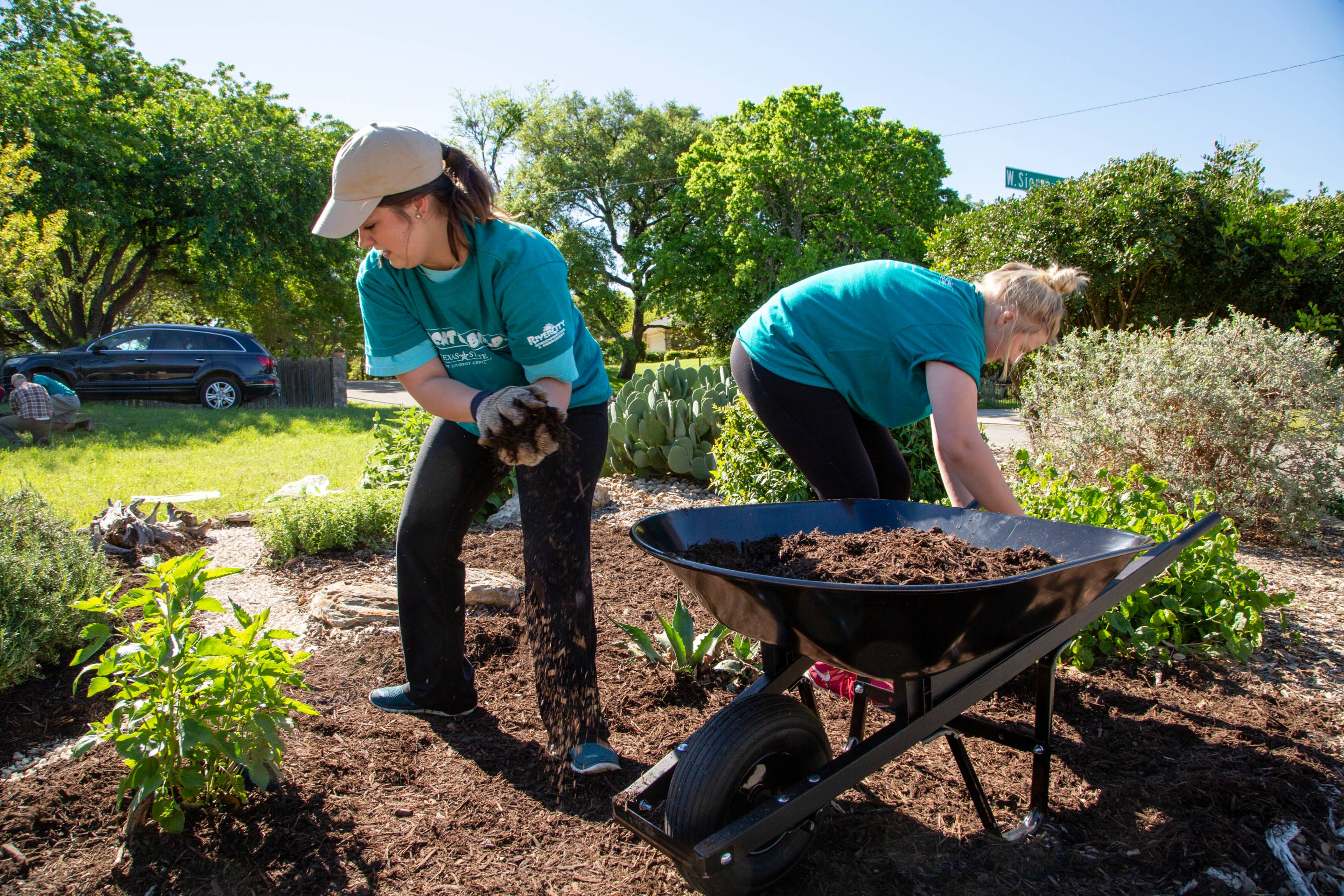 Bobcat Build volunteers in garden with wheelbarrows