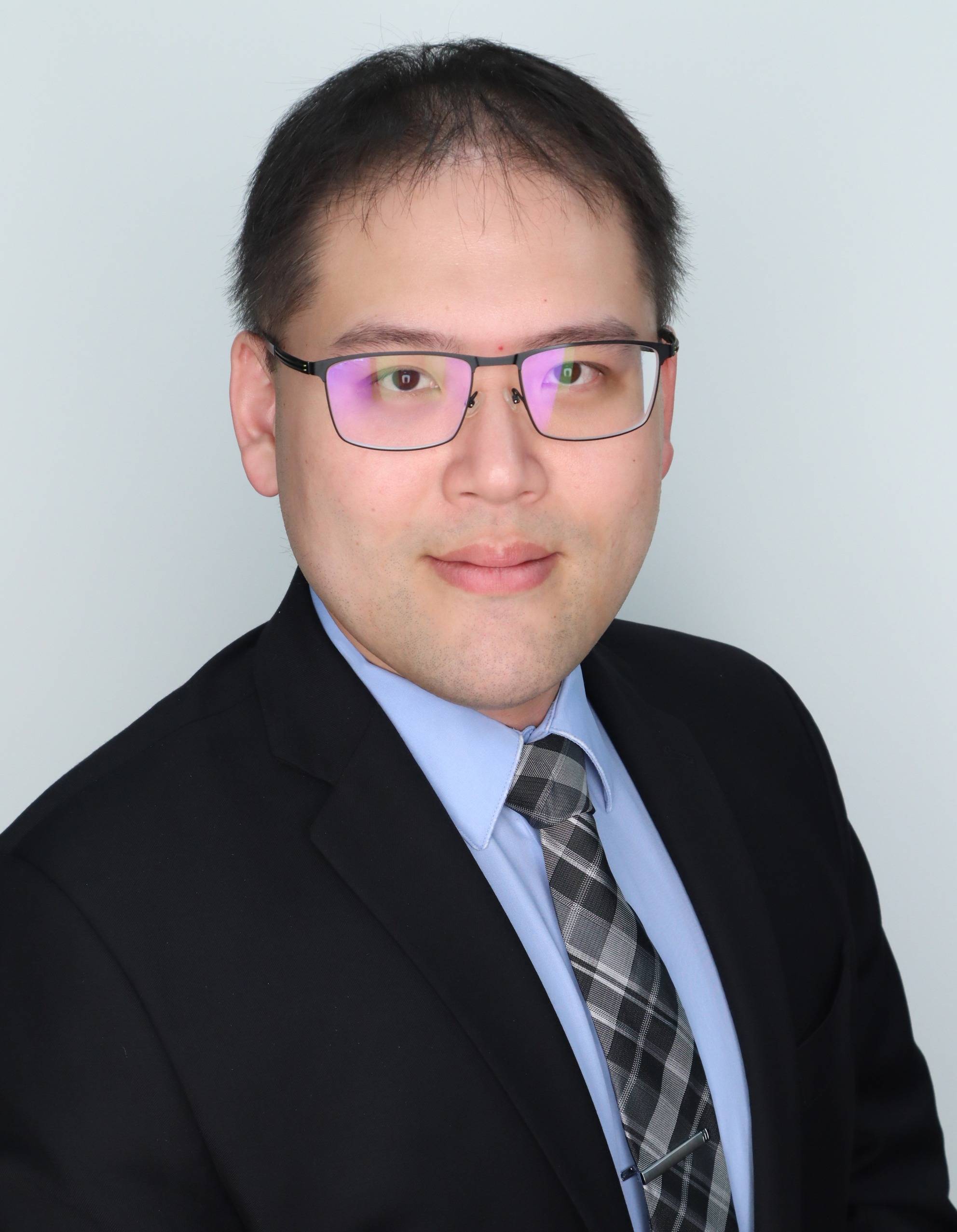 Ethan Chou headshot, wearing a navy blue suit with a light blue shirt