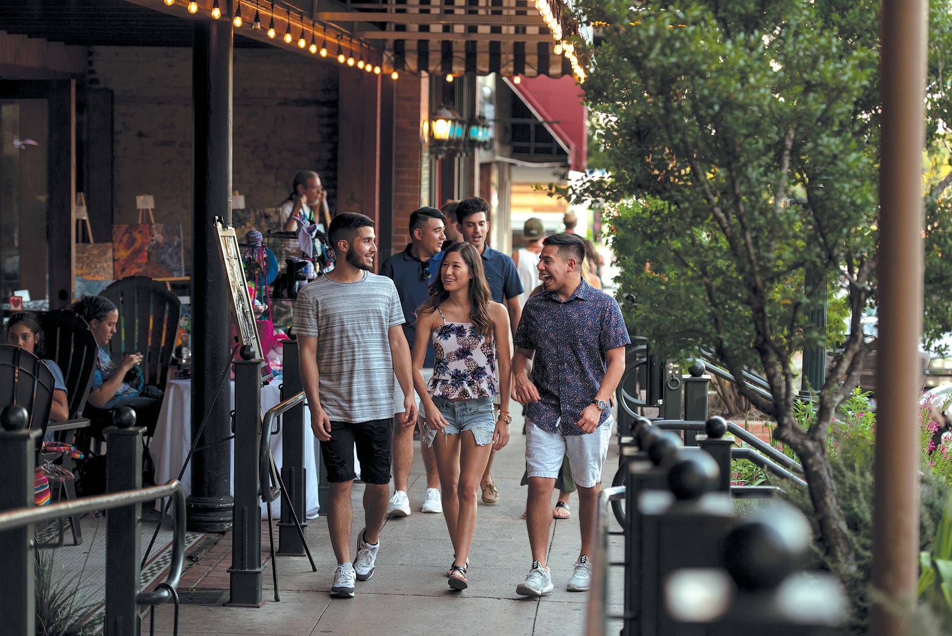 3 students walking down a busy sidewalk in downtown San Marcos