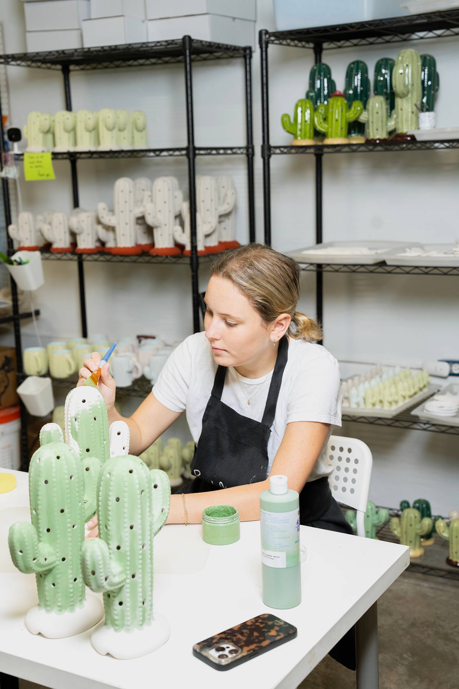 Brush Strokes employee paints ceramic cactus.