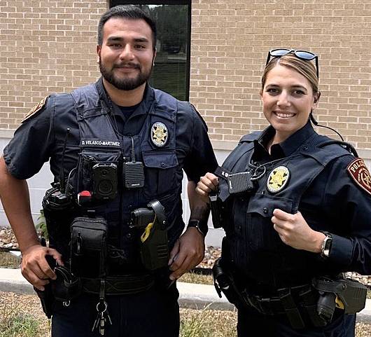 two police officers standing in front of a building