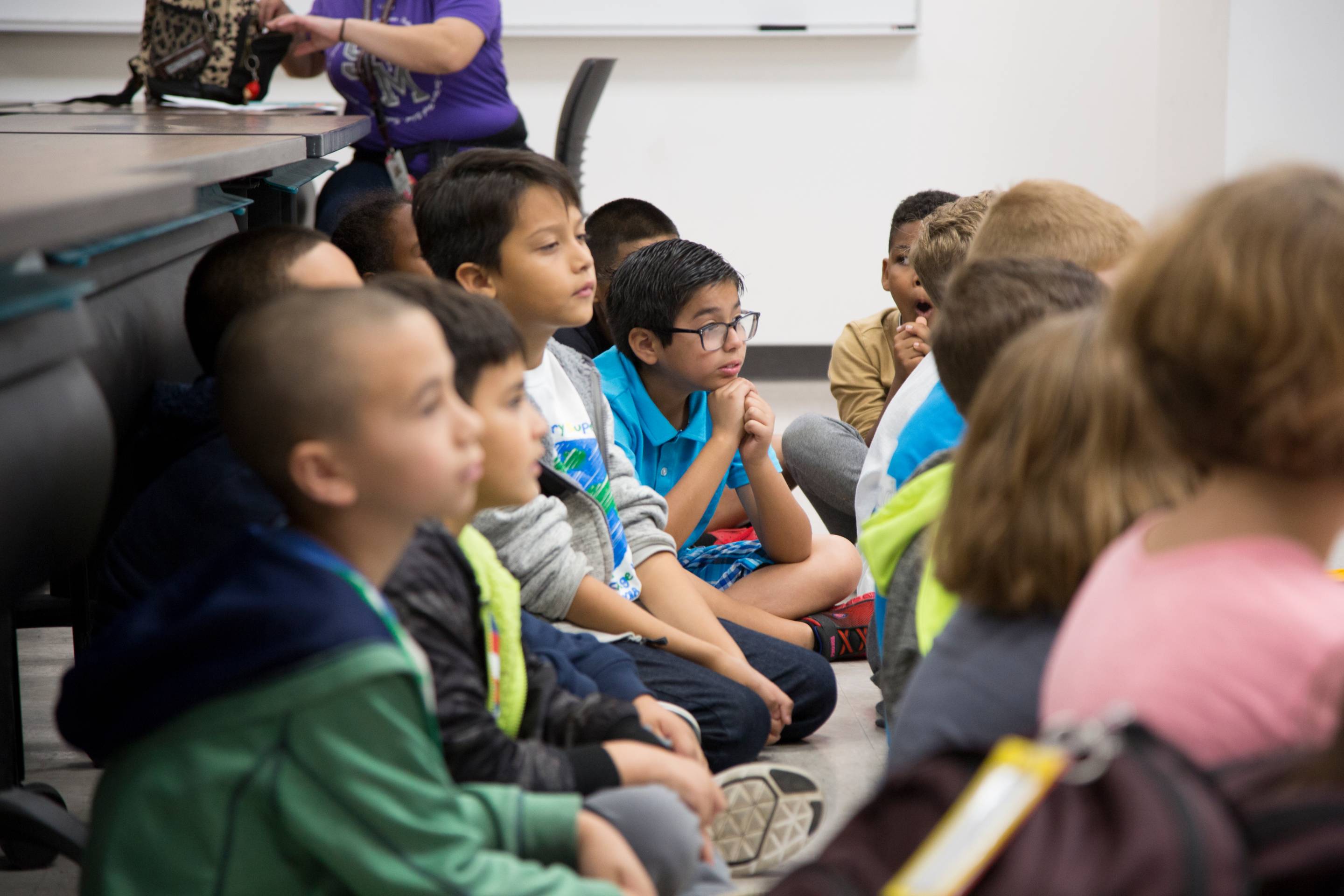 Elementary school students listening to a Texas State University presenter