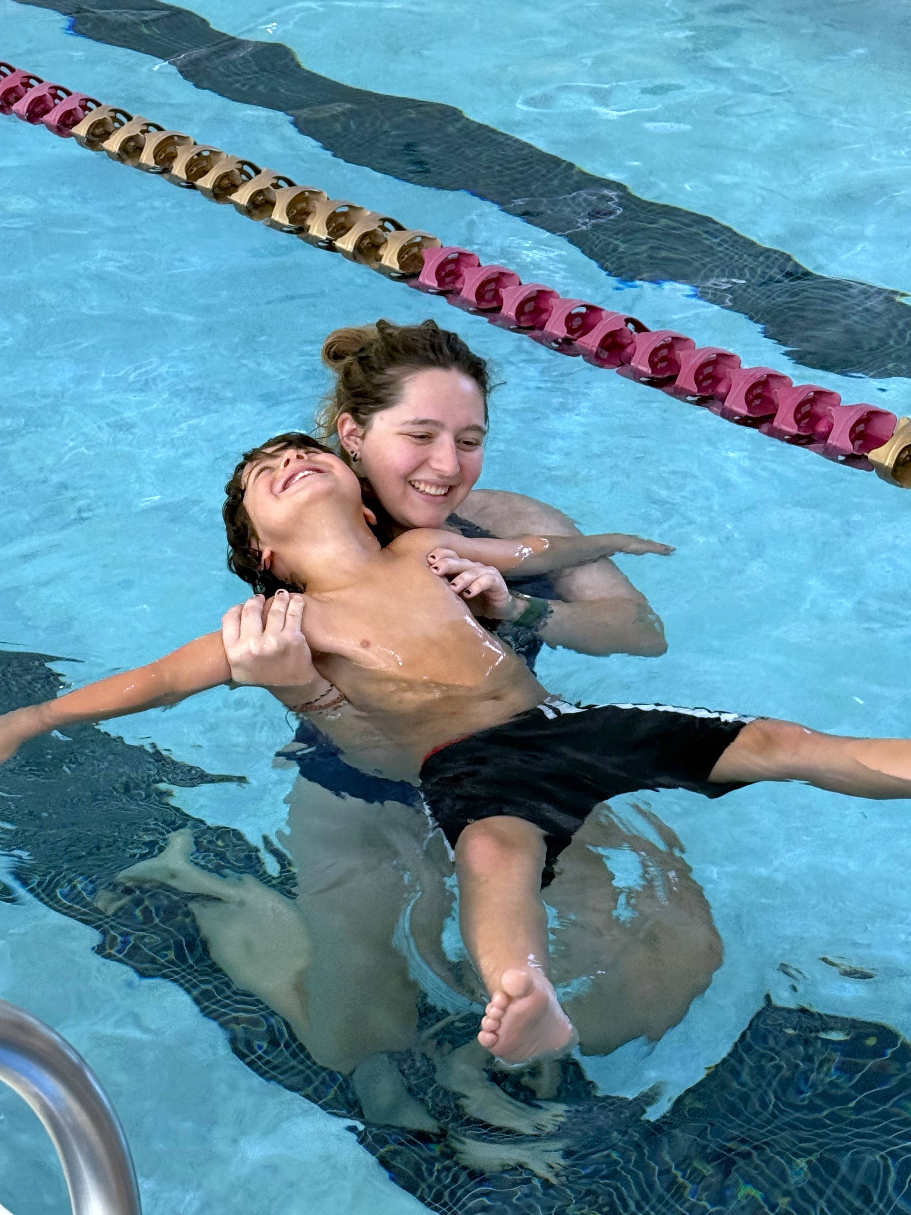WSI helping child float in the water. 