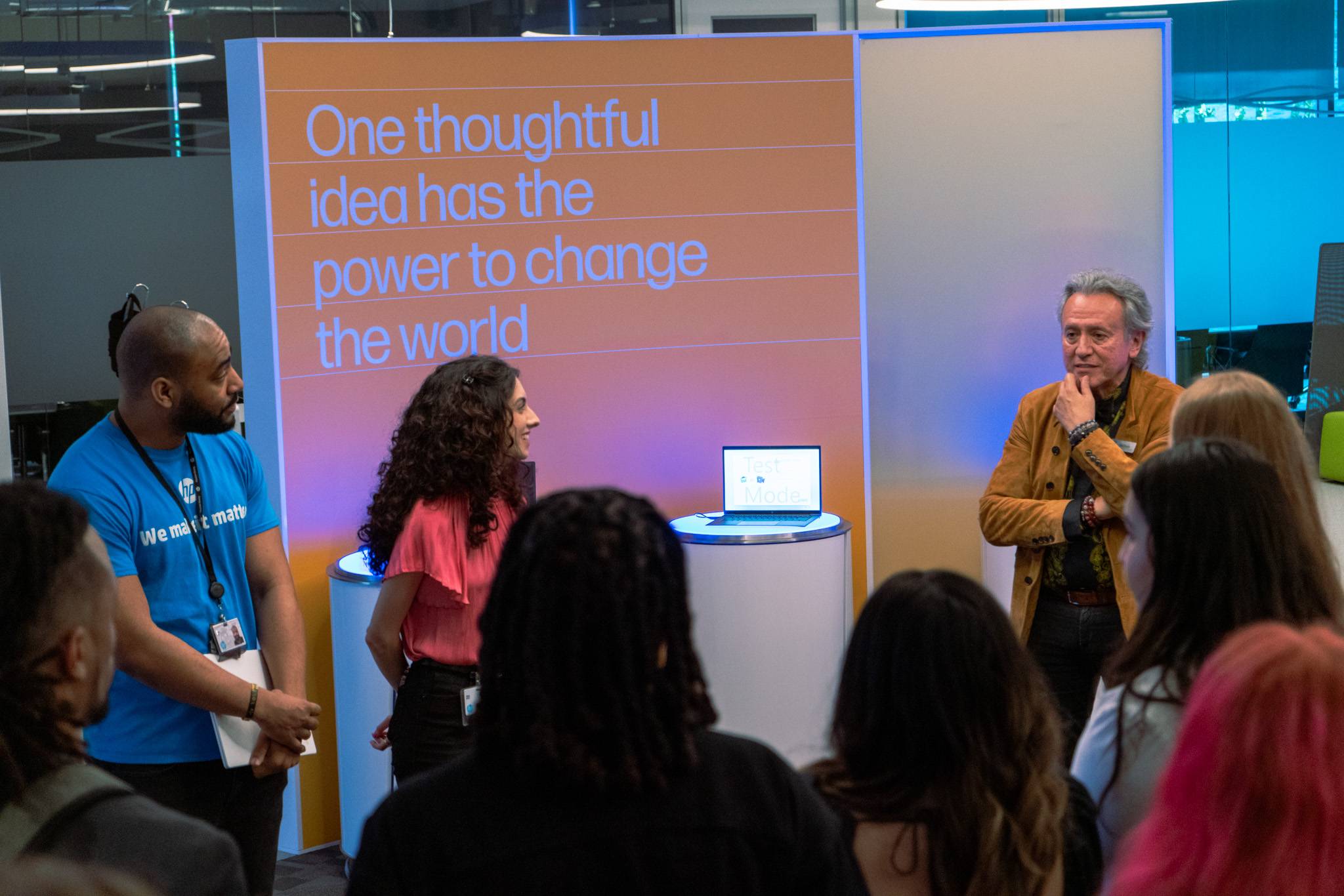 Group of students listening to a professional at an exhibition booth