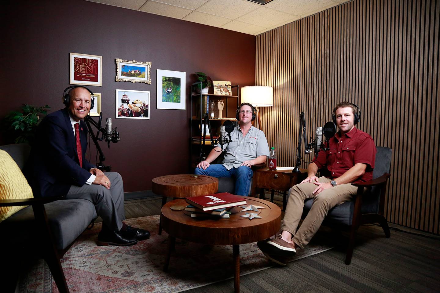 three men sitting in chairs and smiling