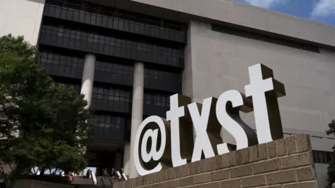 Big "@txst" letters in front of Alkek Library