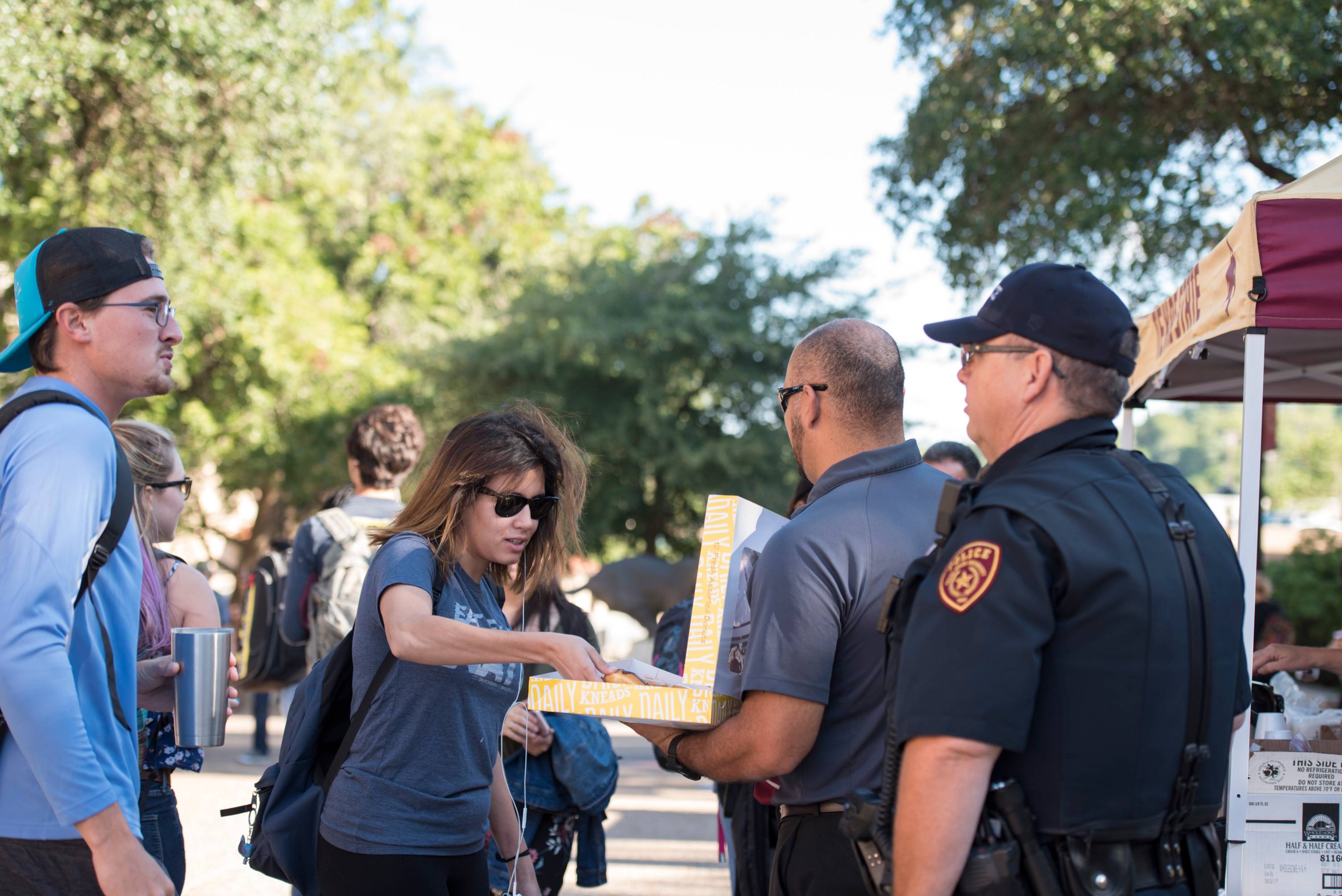 Photo of University Police Officers giving out donuts to students