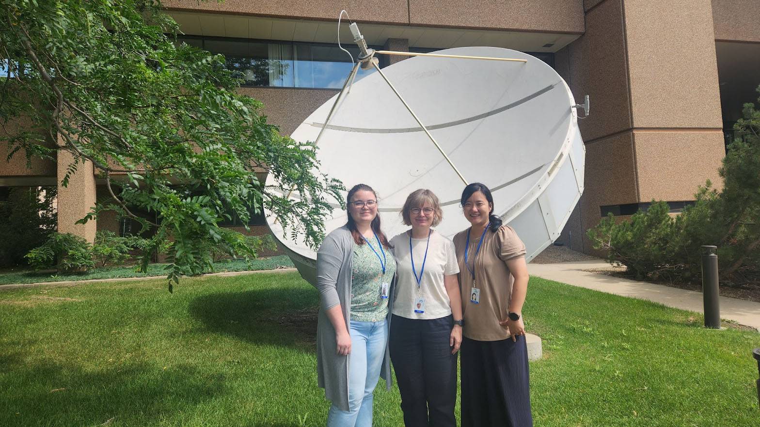 Koehler (left), Graves and Choi pose for a photo in front of a satellite at the National Center for Atmospheric Research.