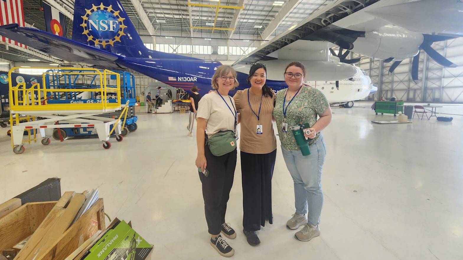 Amanda Graves (left), Shinwoo Choi, Ph.D., and Lacey Koehler pose for a photo in front of the National Science Foundation airplane.