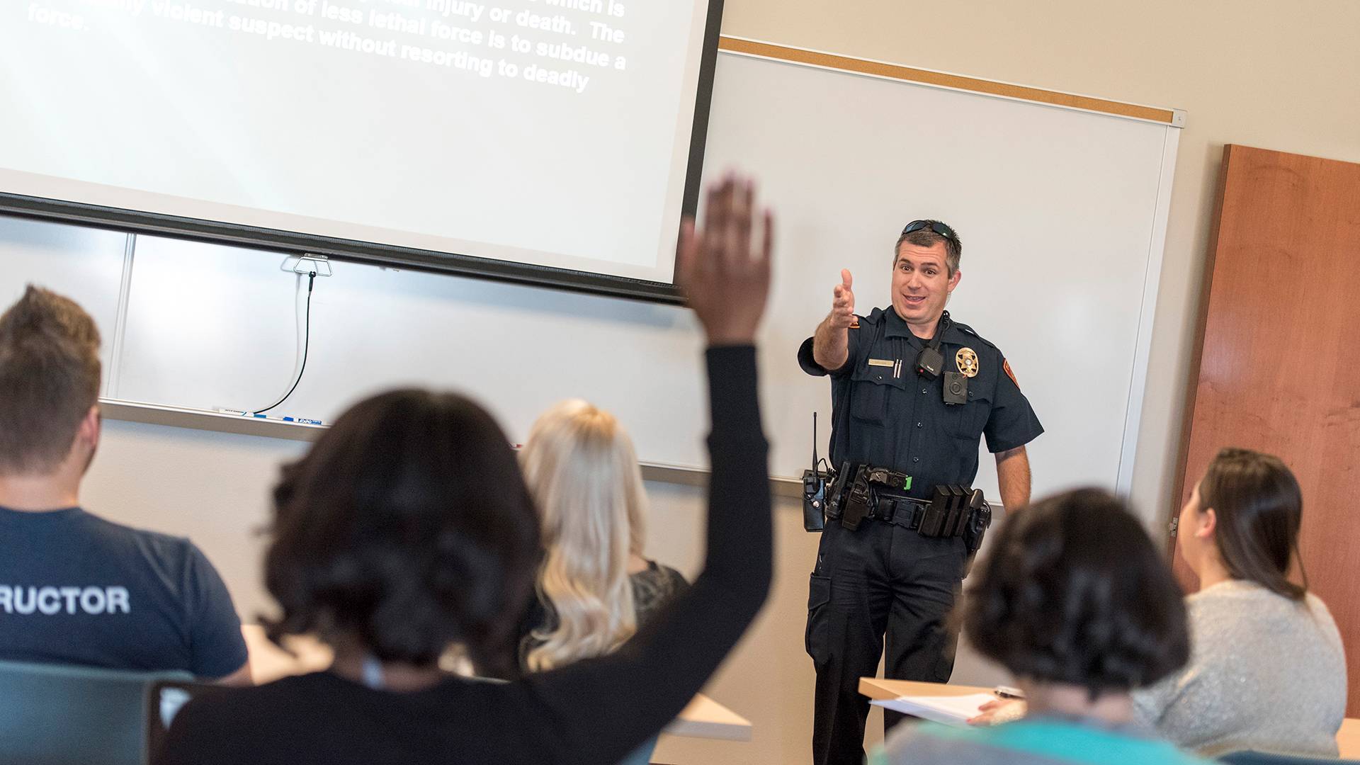 a police officer speaking to a student in a classroom