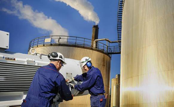 2 men working in hard hats at a chemical plant