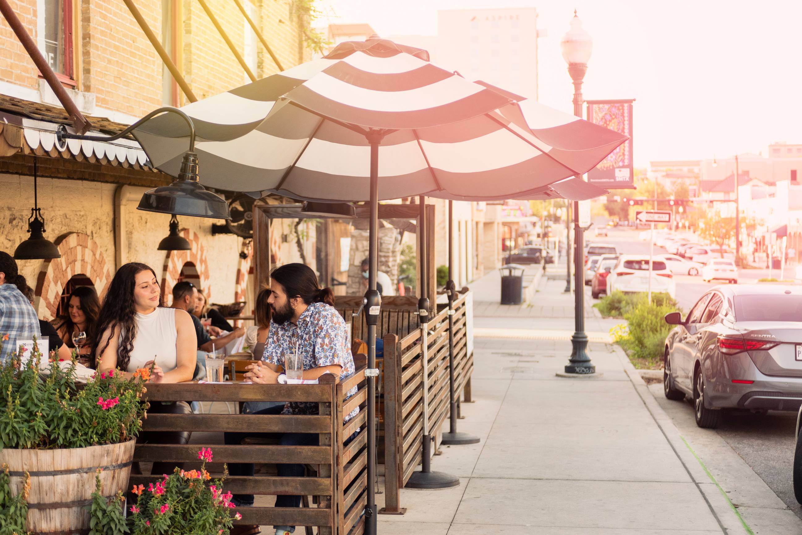 People sitting and eating in the patio area of a downtown cafe