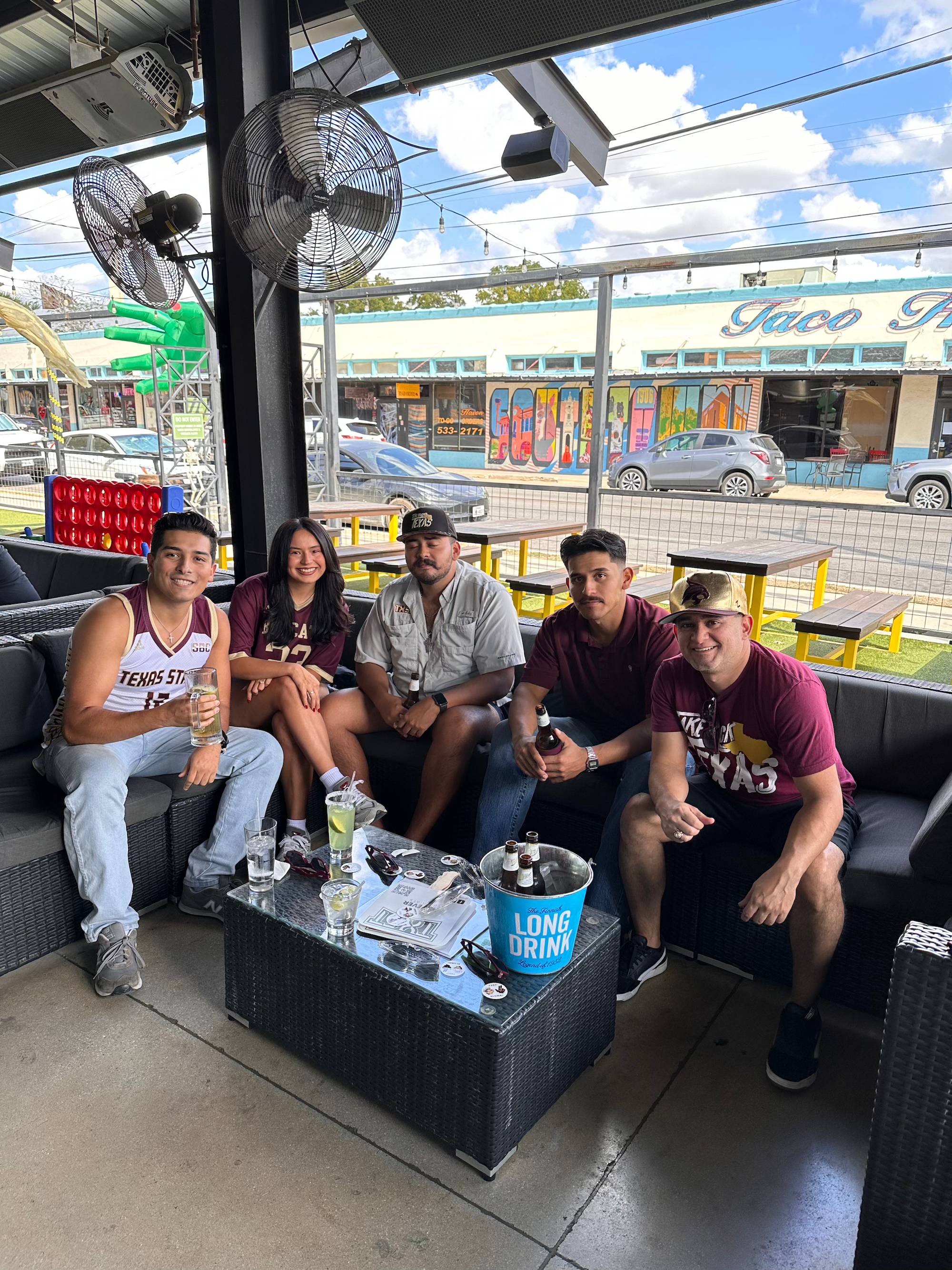 Group of Texas State fans sitting at a table during a watch party