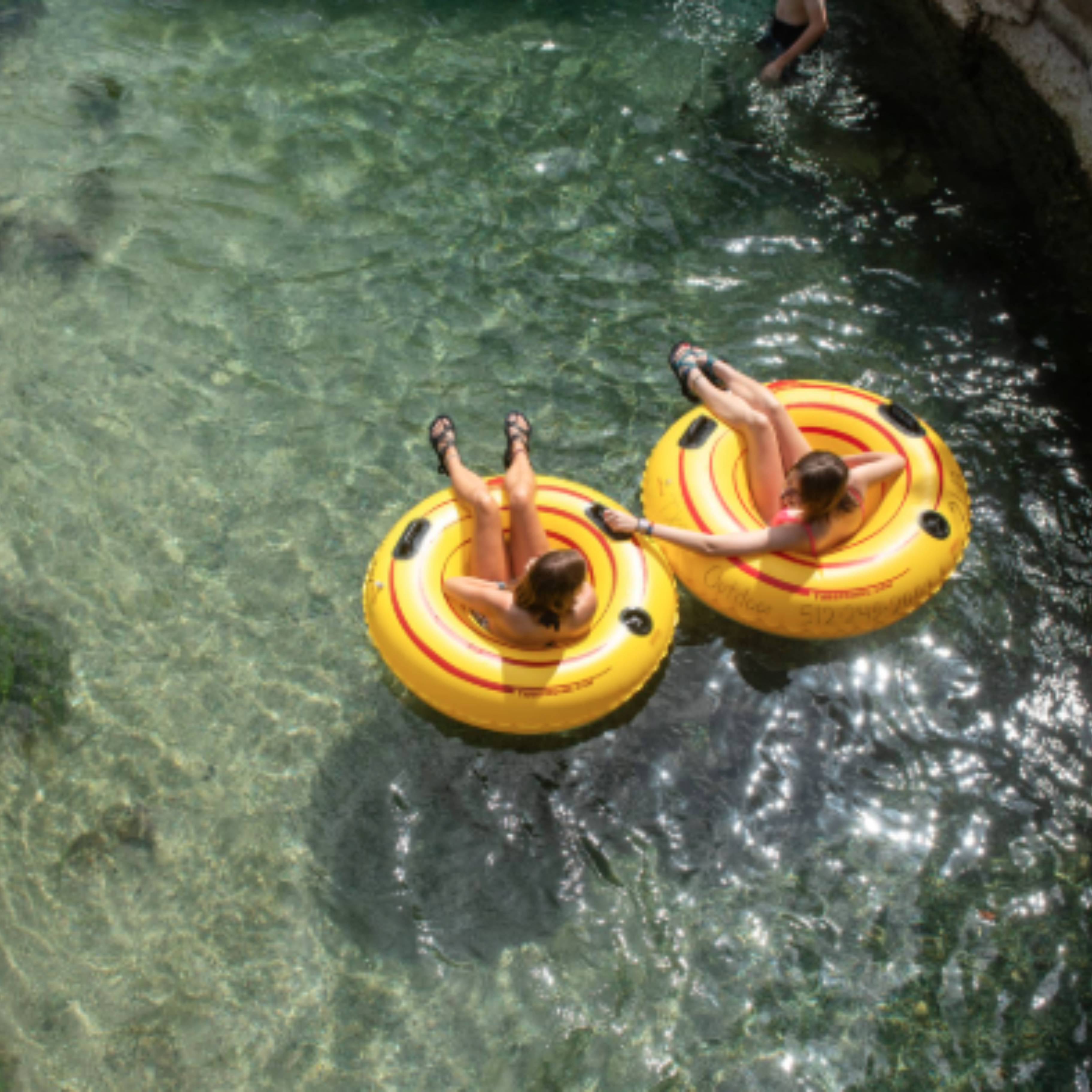two people floating in yellow tubes on a river
