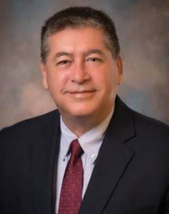 portrait of man in dark suit with crimson tie