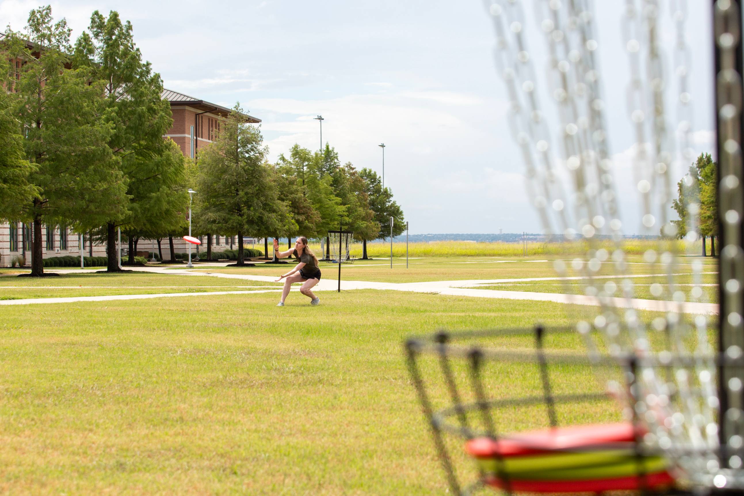 Student playing disc golf on campus