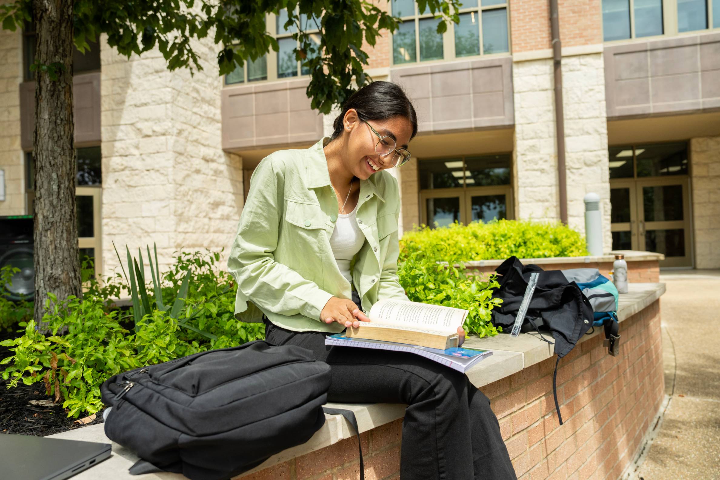 Student smiling and reading a book