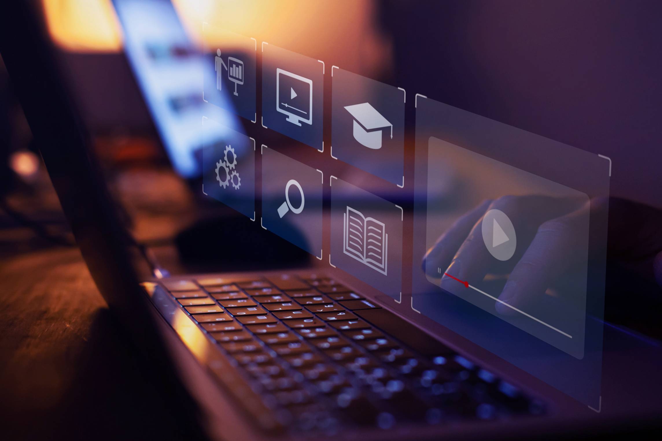 Dark image with a laptop and small icons for play, search, system, books, degrees