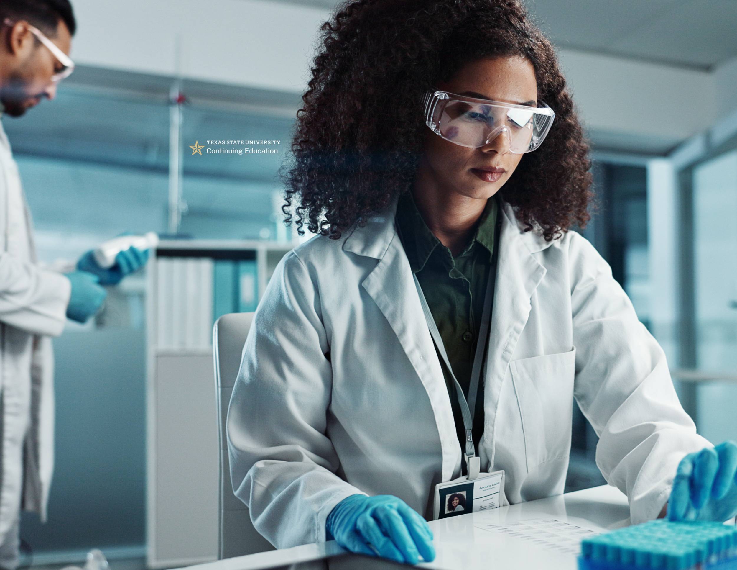 doctor looking at bottle and other doctor at table examining test tubes