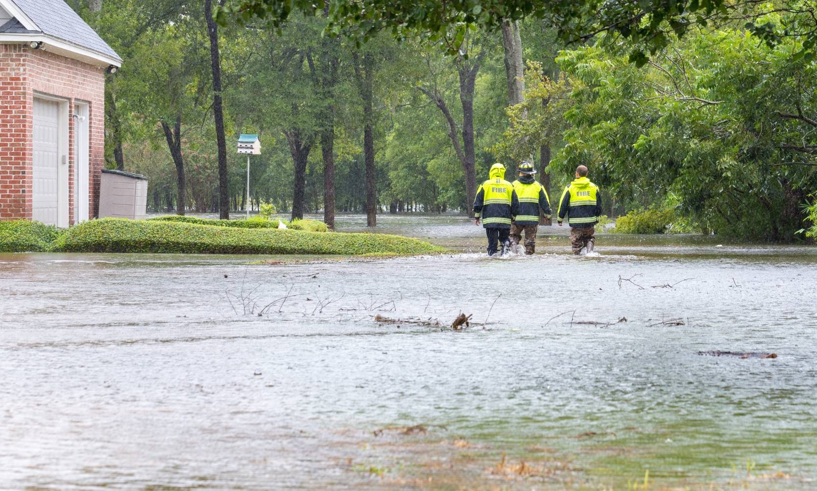 First responders walking through flooded streets in Texas neighborhood.