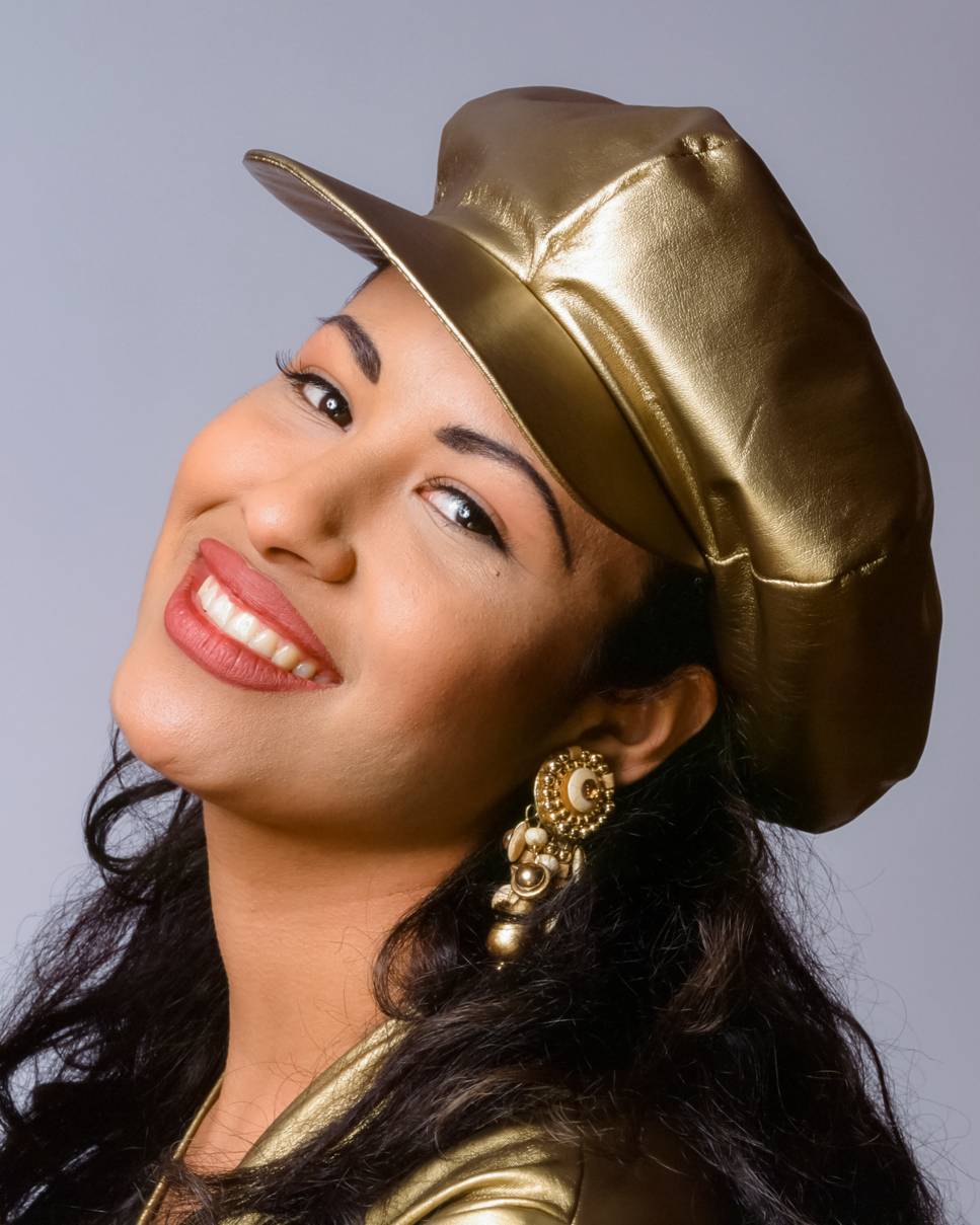 headshot of a woman wearing a gold cap
