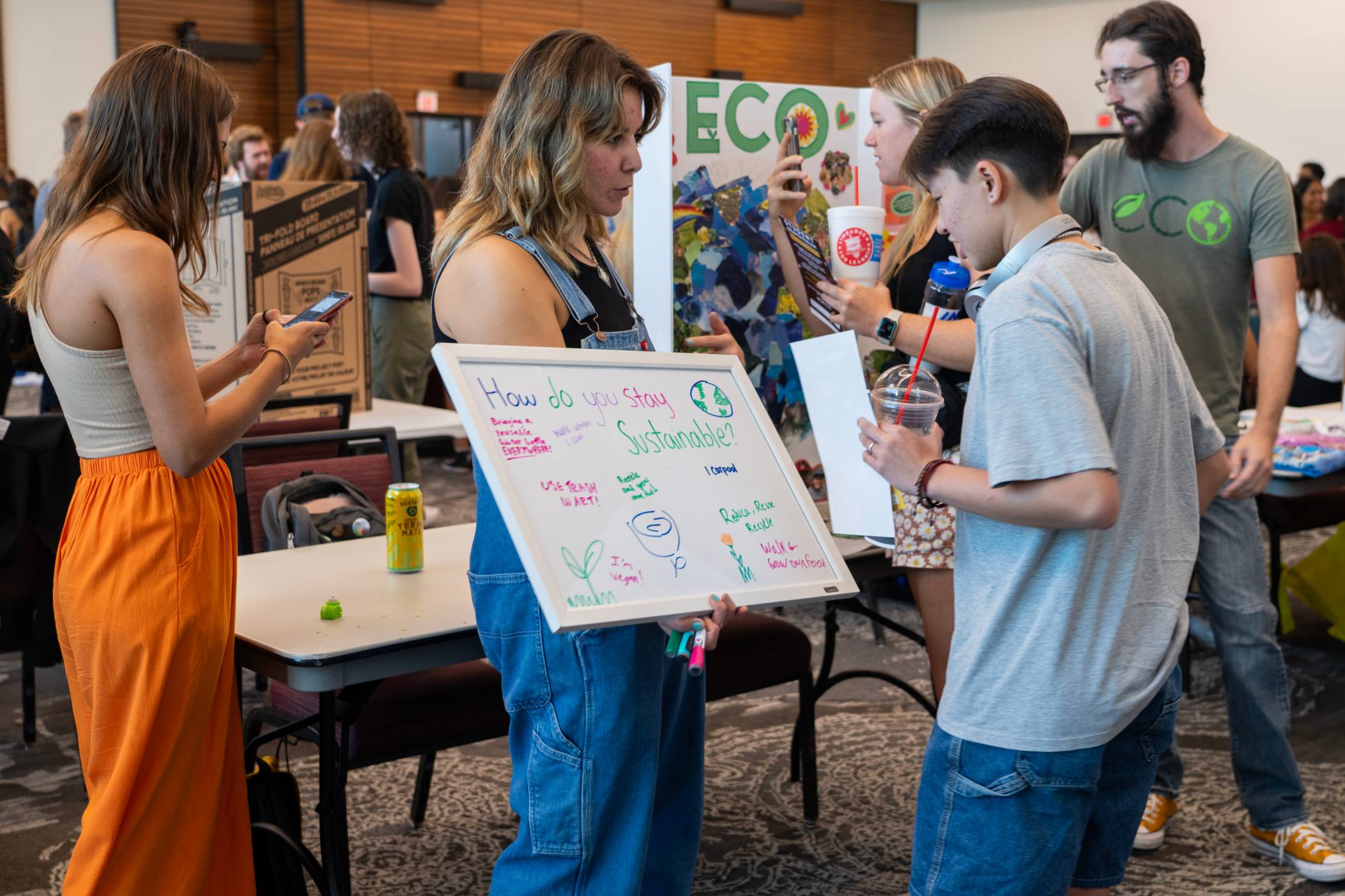 student holding a poster board while another student reads 