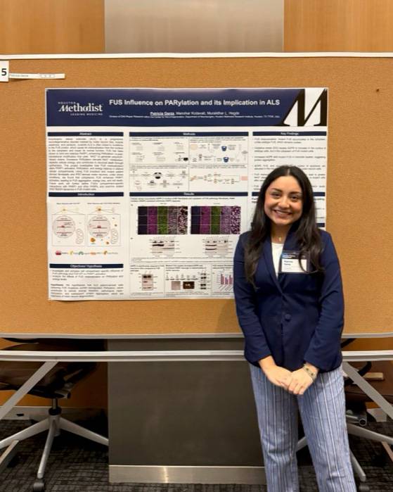 Patricia Garza poses for a photo in front of a research poster.
