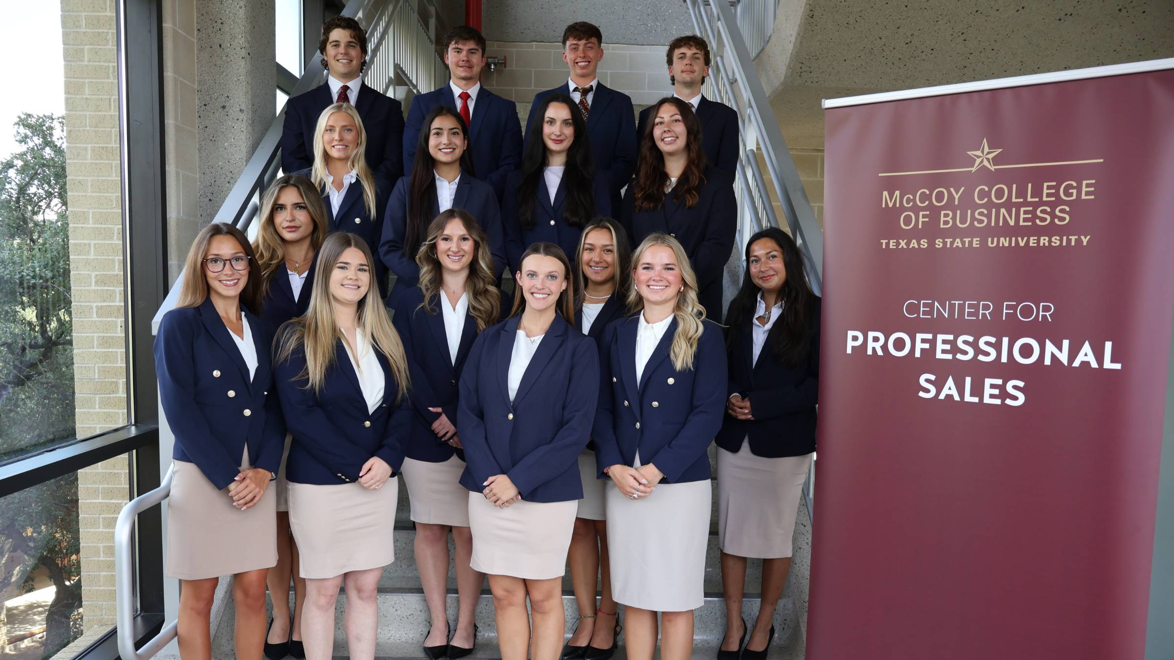 students in business professional smiling for a photo