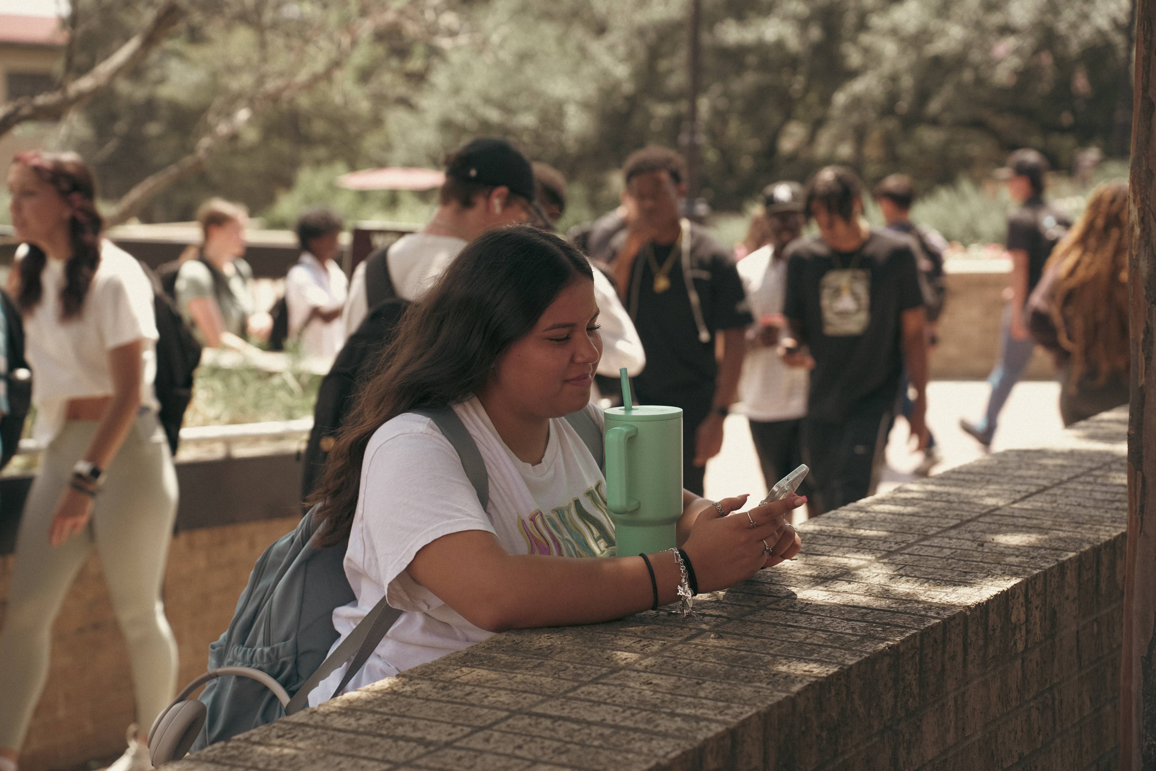 Student reading her phone outside