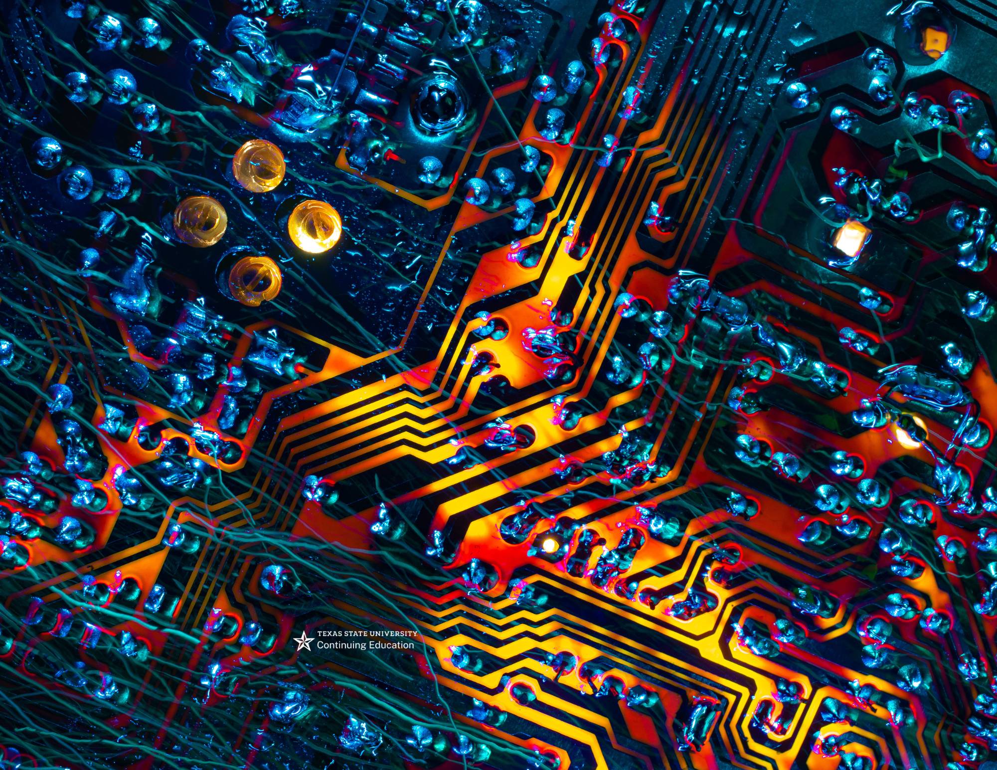 circuit board in yellow and red with blue droplets on it