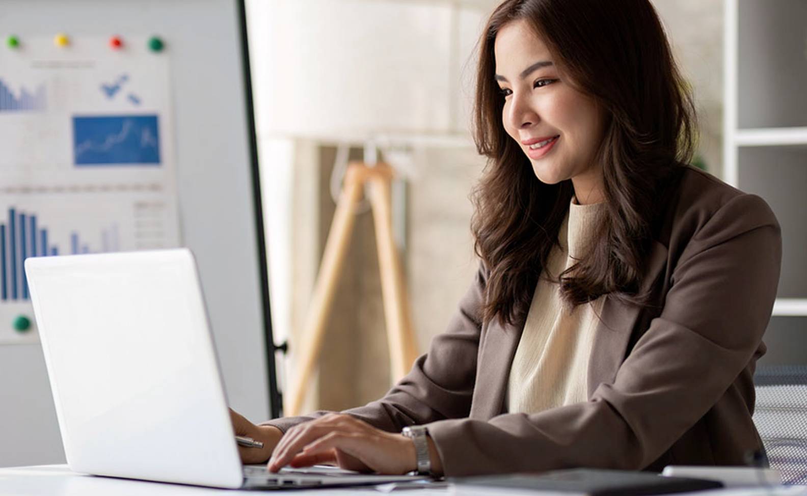 A woman in suit sitting at a desk.