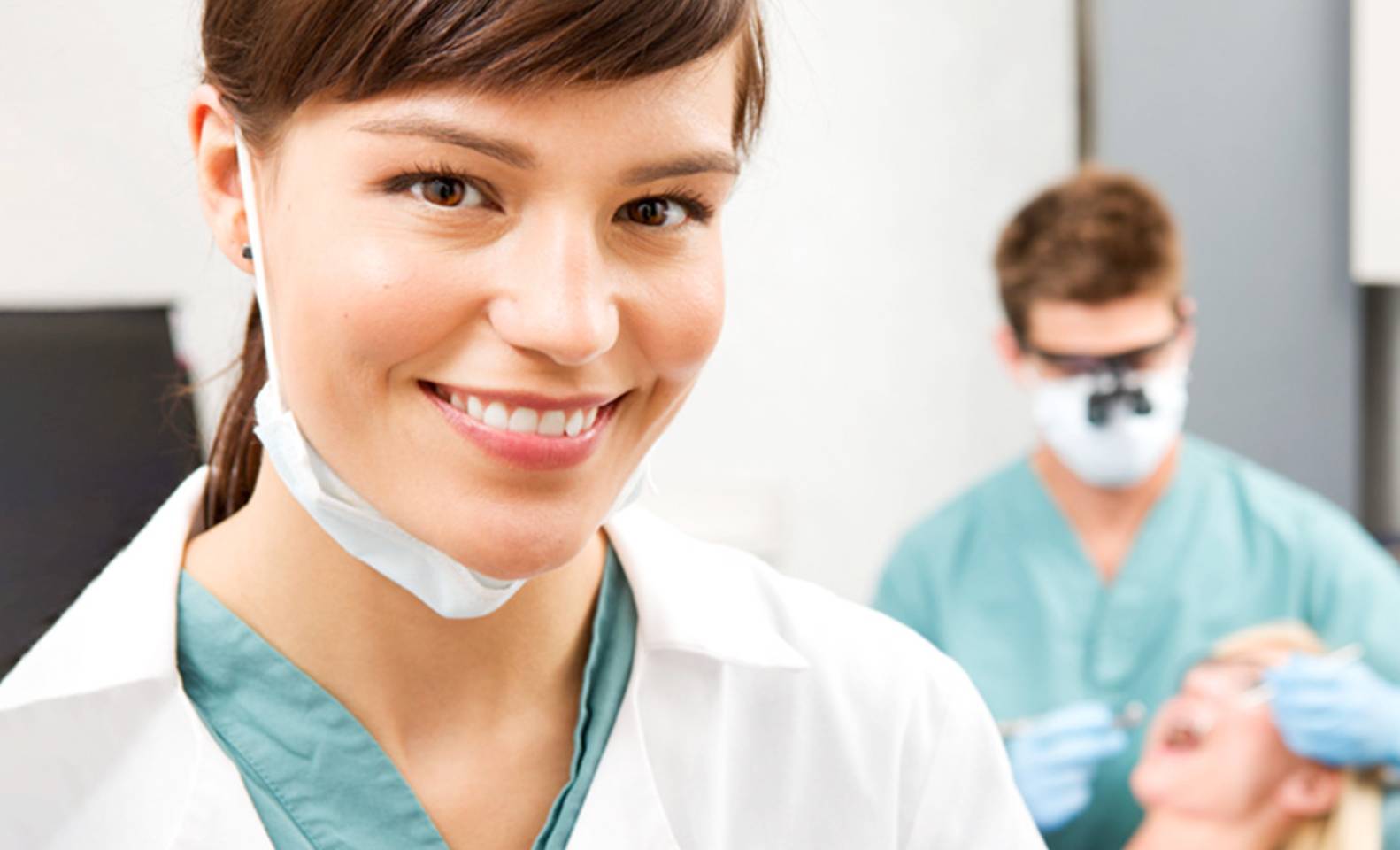 A dental assistant holding dental tools.