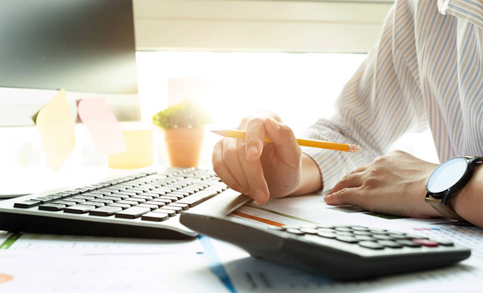 People writing on papers on a desk