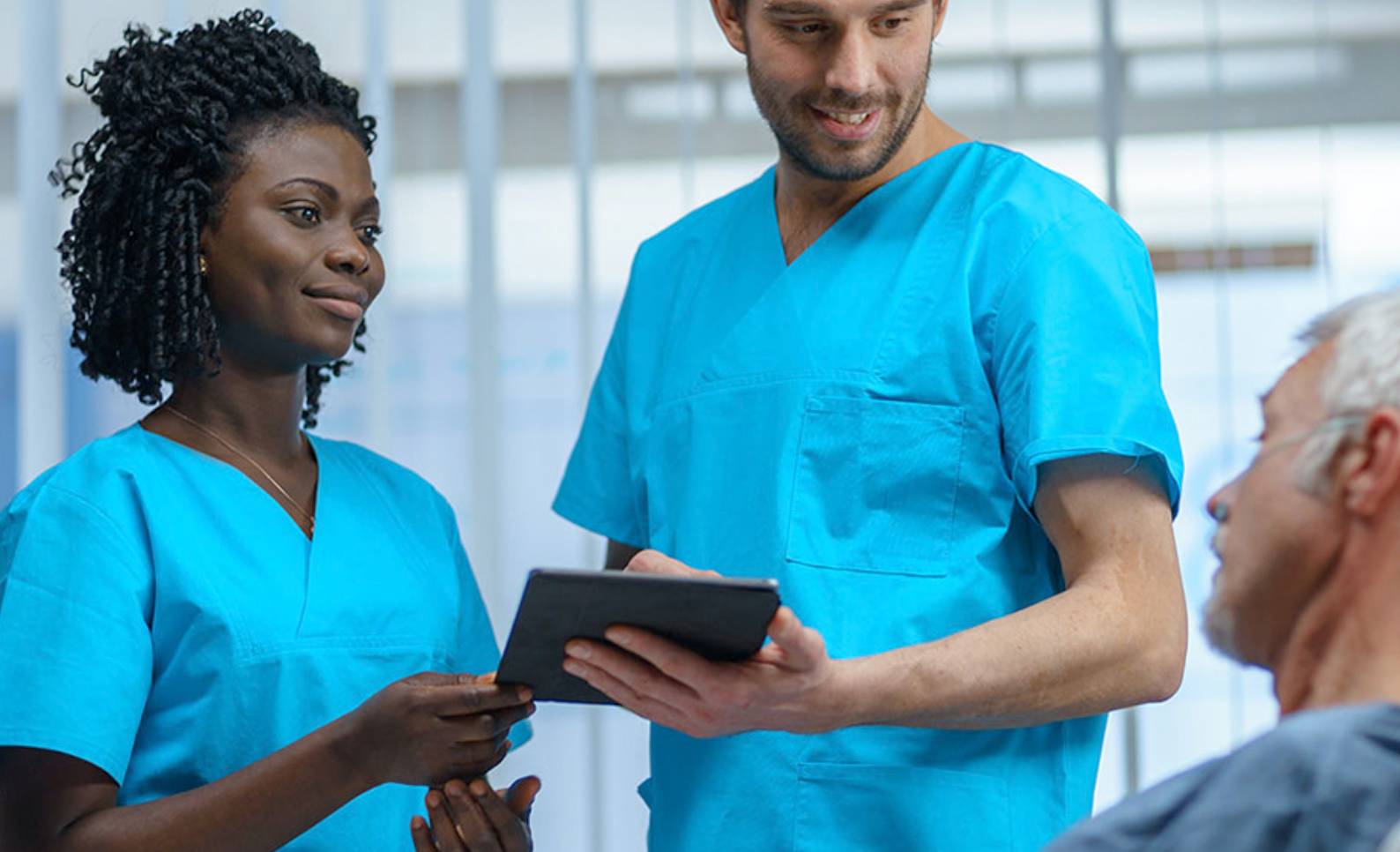two nurses helping a patient in a bed