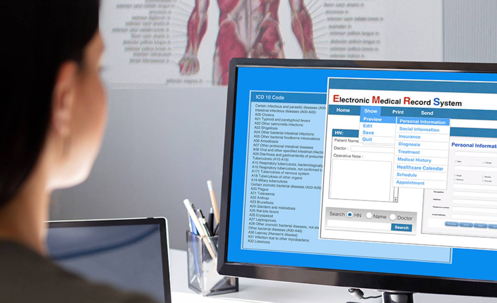A woman sitting in front of a computer with medical records on it. 
