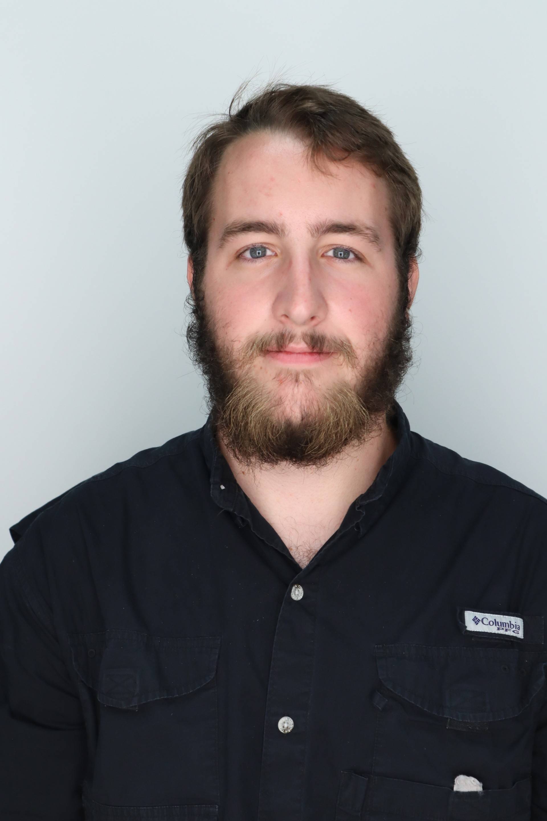 A man with a beard and black shirt is framed center