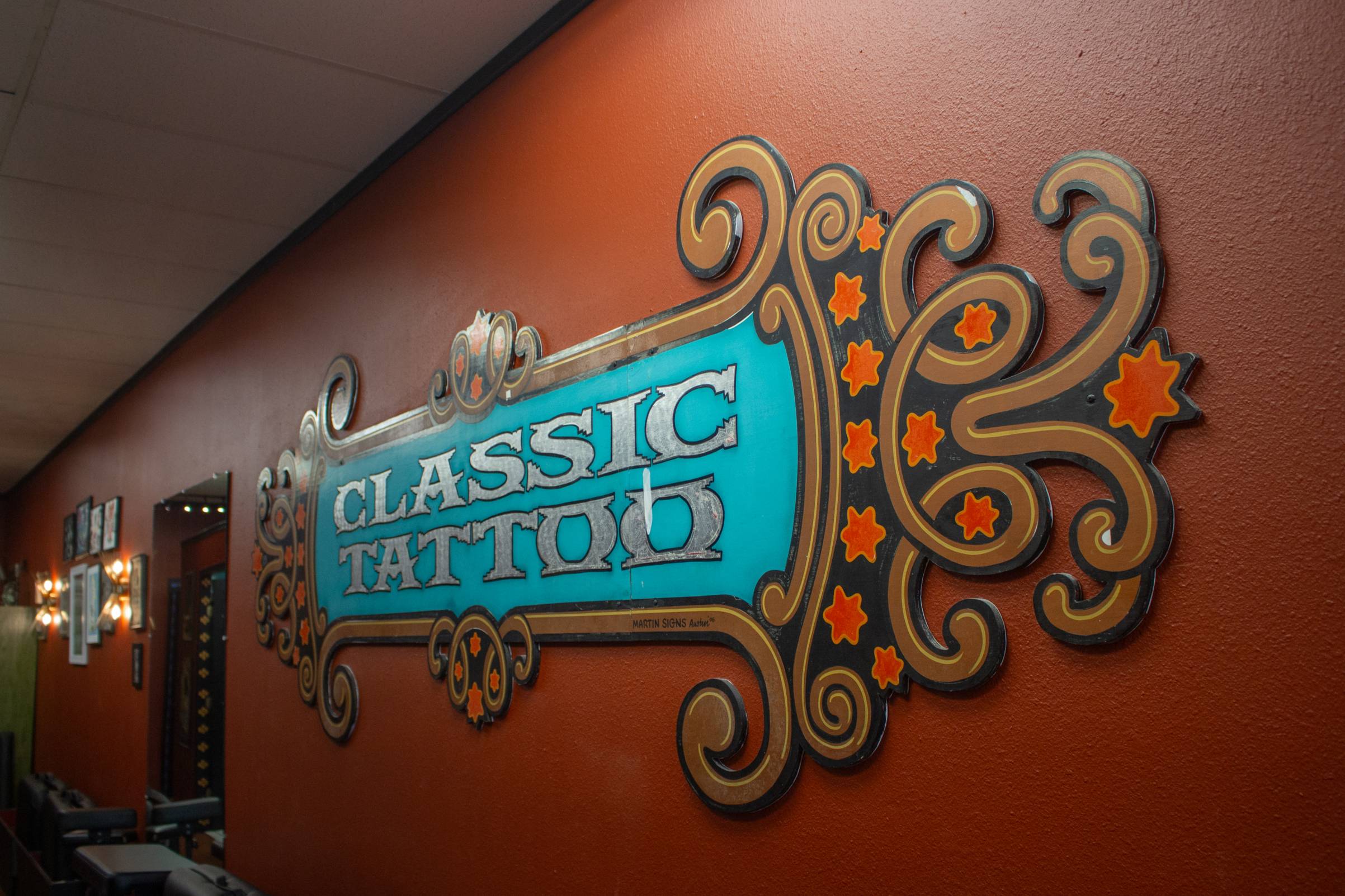 large sign reading "classic tattoo" on a red wall