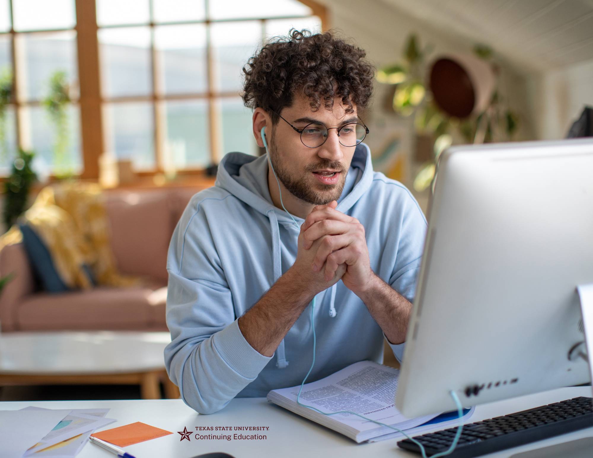 man with headphones reading a laptop screen