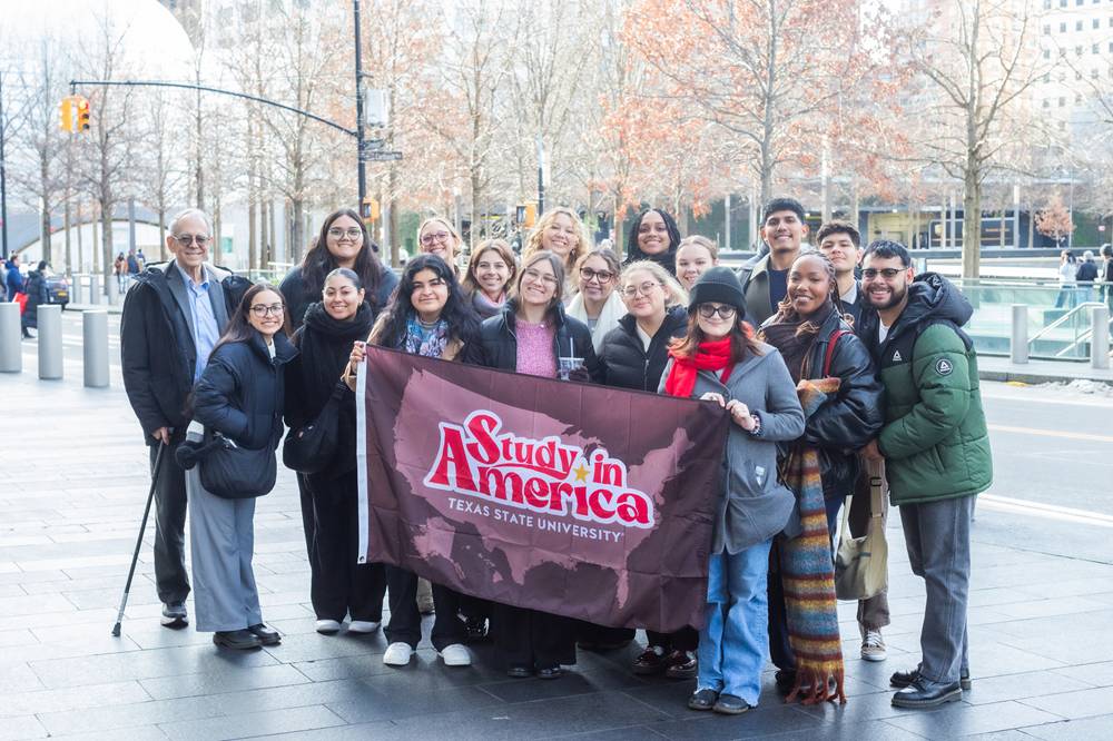 TXST students in NYC holding Study in America flag