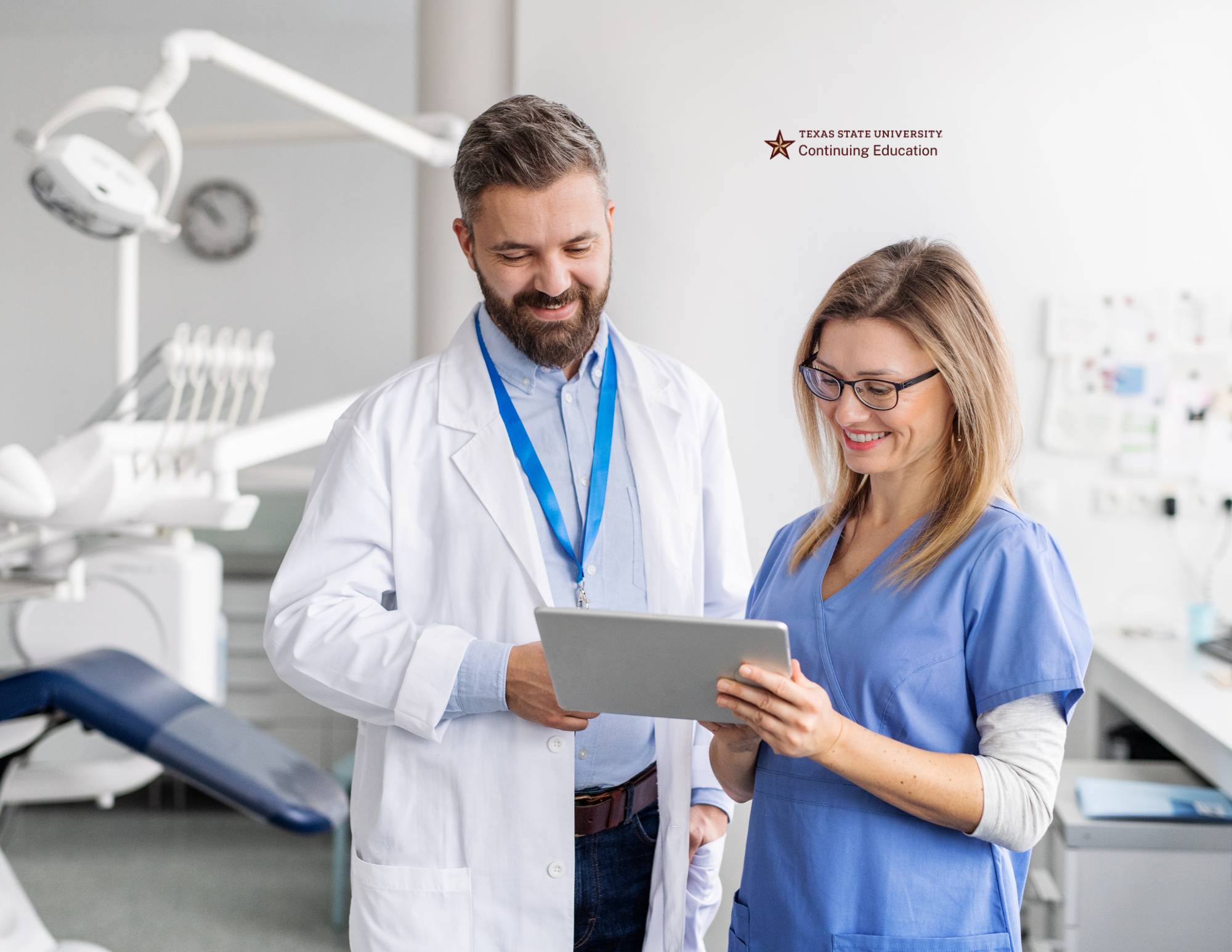 a dentist conferring with a nurse in front of a dental chair