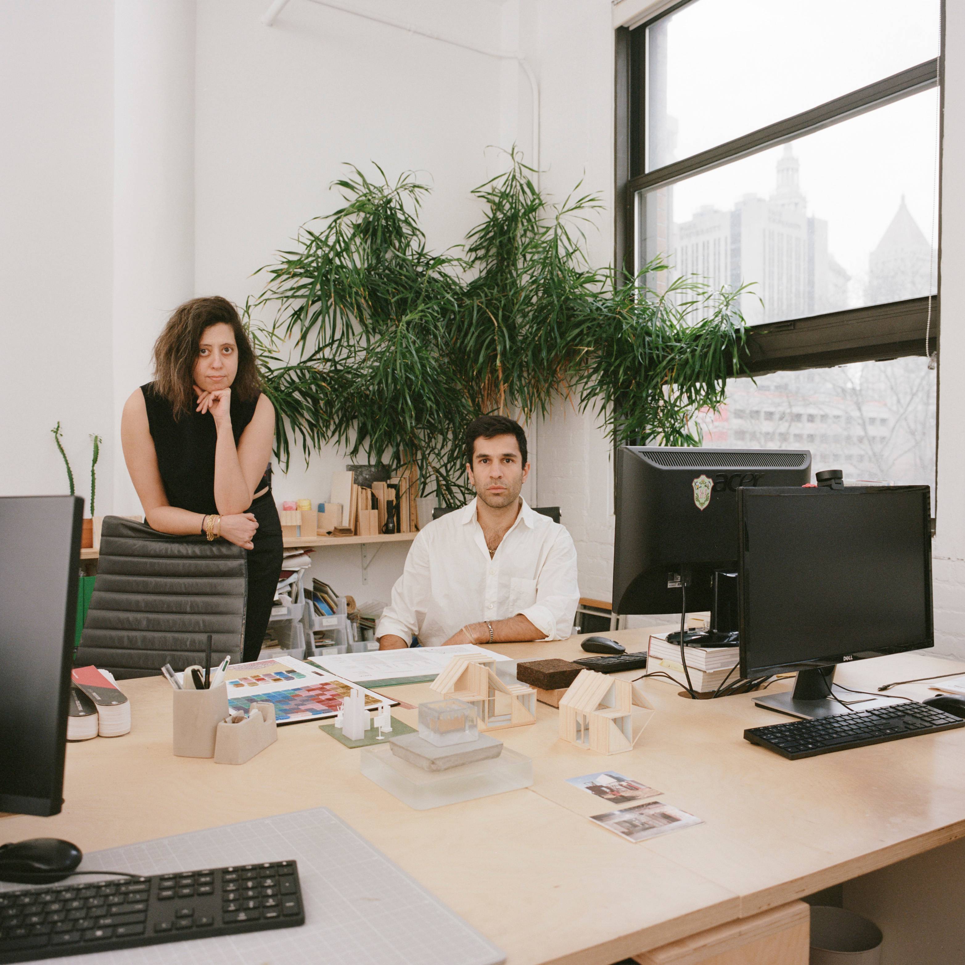 A man and a woman posing behind a desk