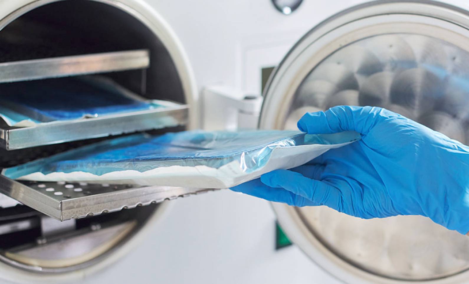 gloved hand placing test tray in tester