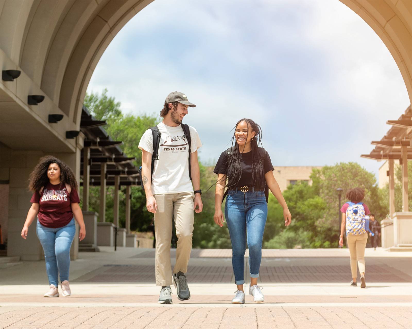 two female students laugh while wearing their texas state apparel