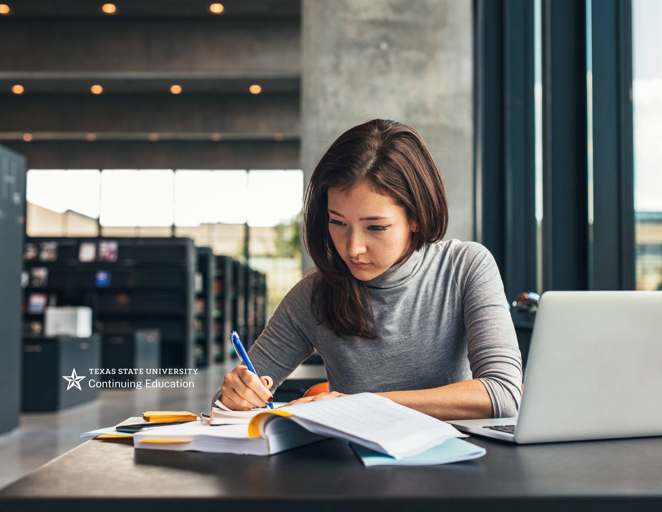 woman sitting in library on laptop