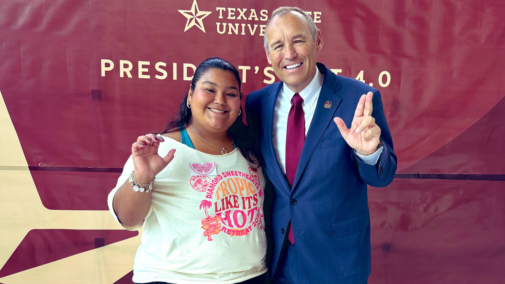 A student (left) poses for a photo with President Kelly Damphousse at the President's List event.