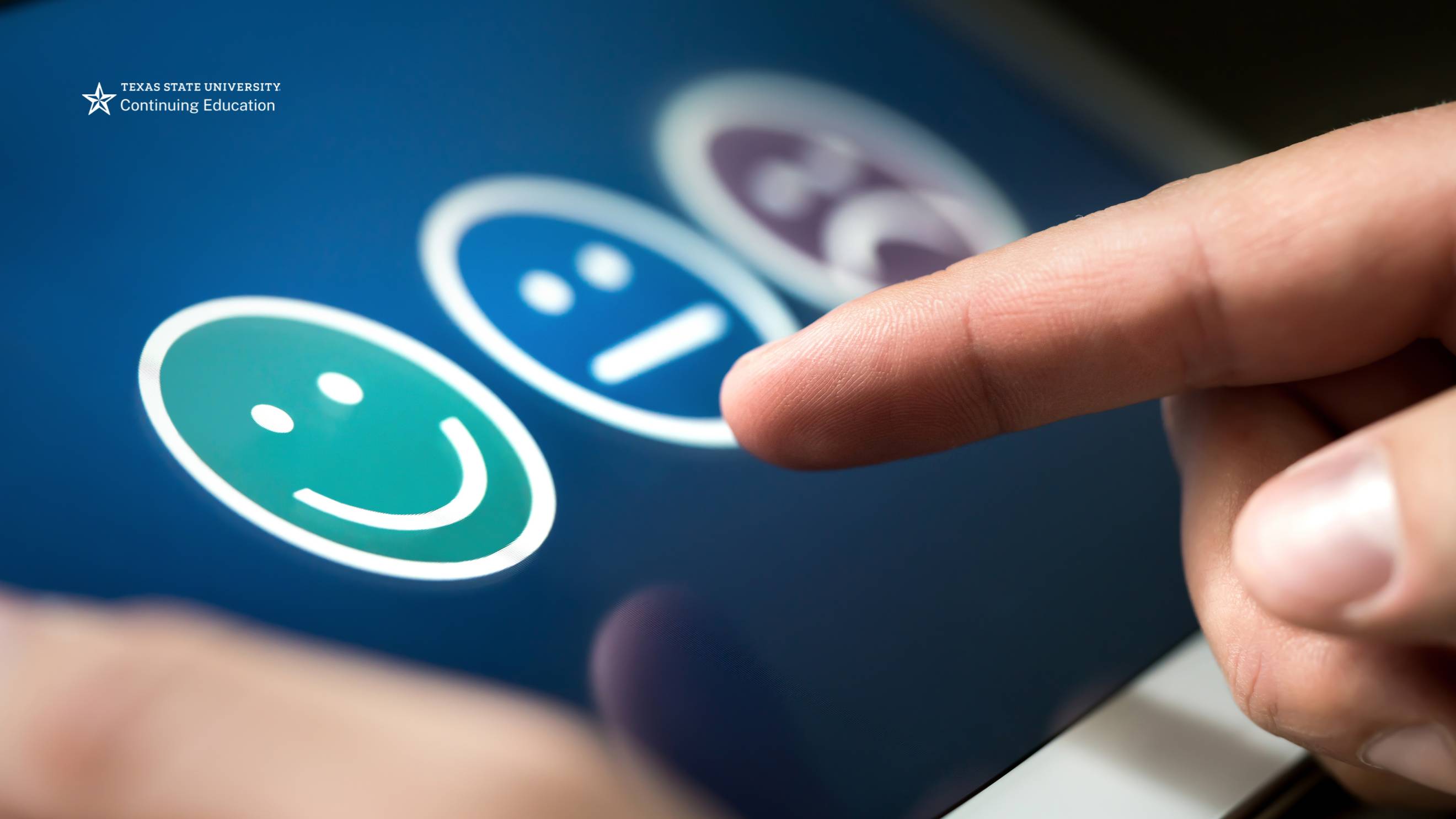 a finger pointing at a blue screen with digital smiley faces on it