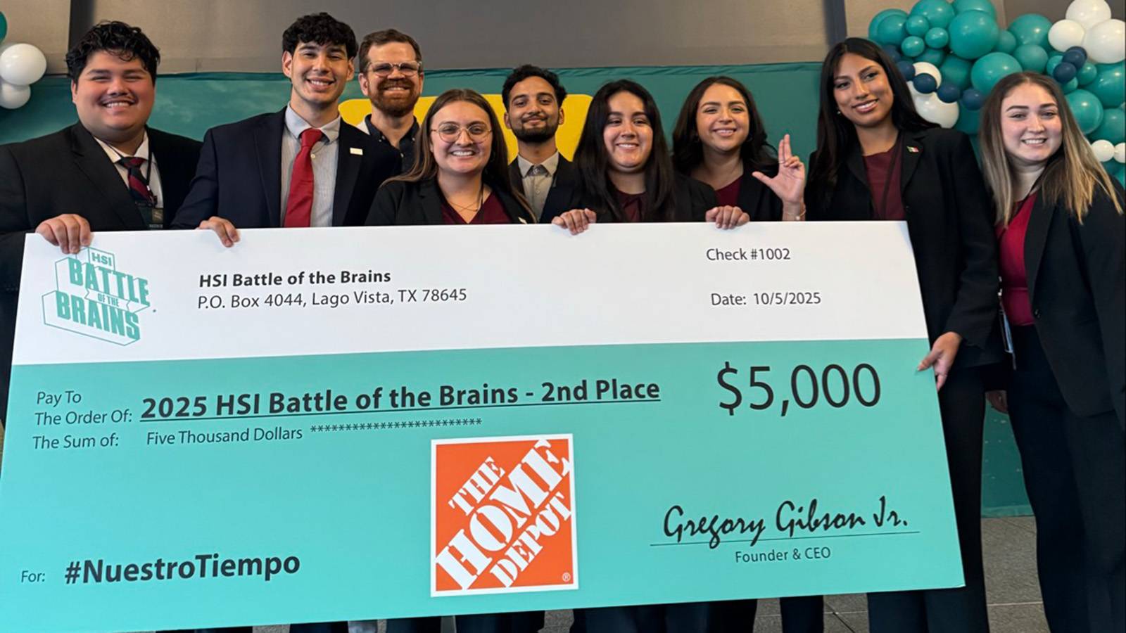 group of professionally dressed students holding giant check