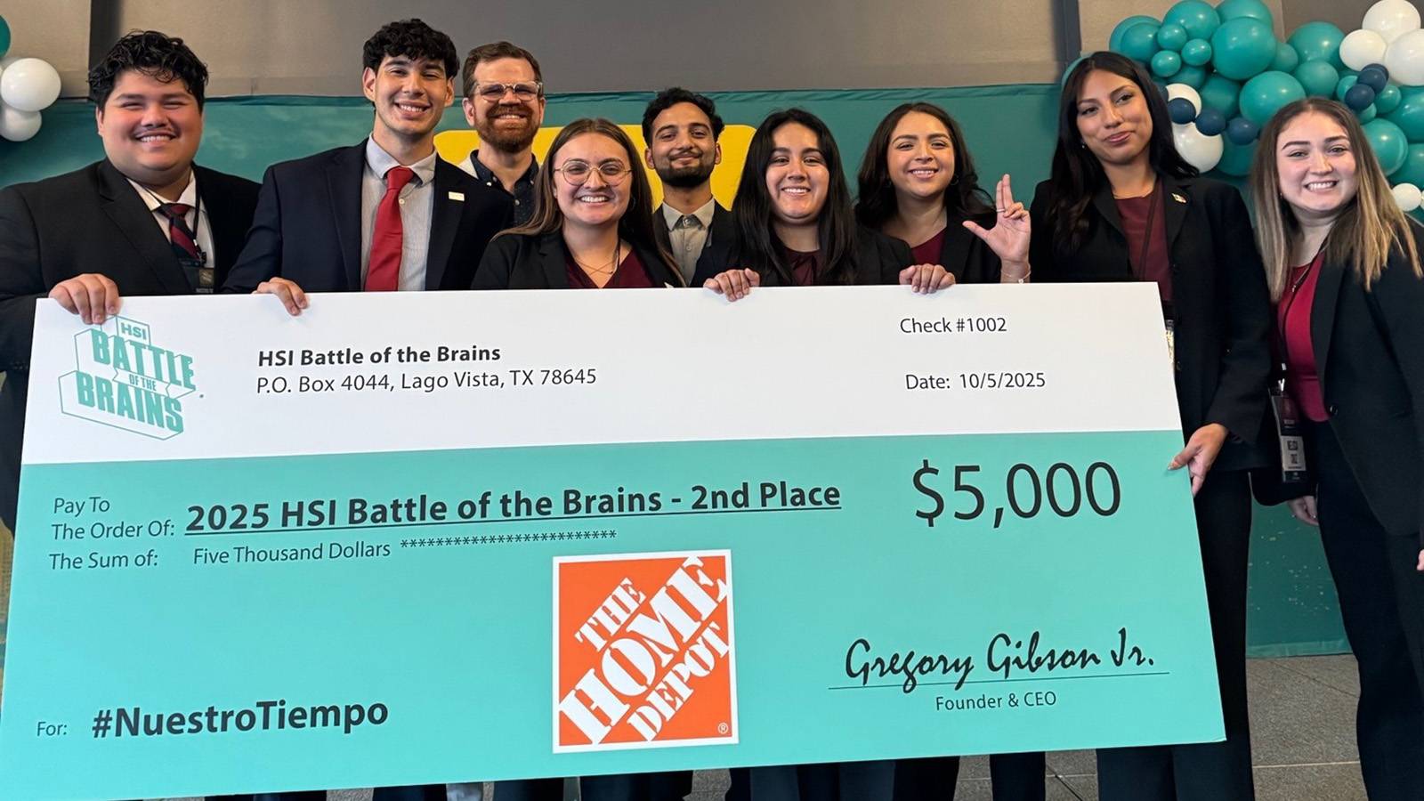 group of professionally dressed students holding giant check