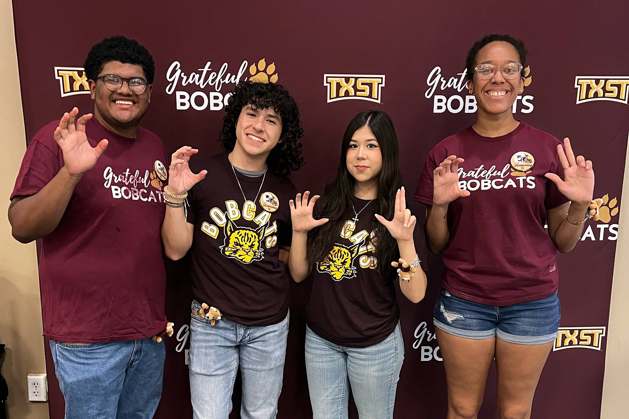 Students in front of a Grateful Bobcats banner
